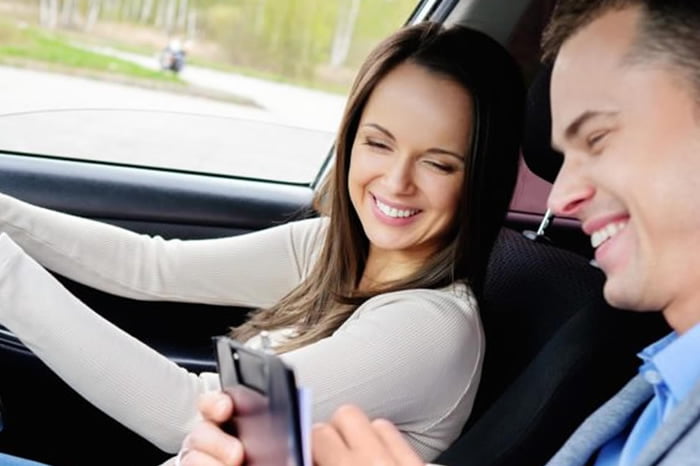 Two people sitting in the front seats of a car